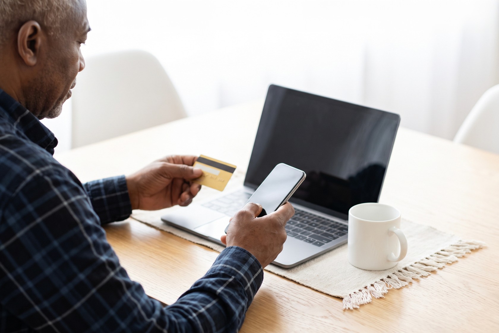 Foto van man met creditcard voor laptop in het kader van phishing