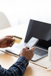 Foto van man met creditcard voor laptop in het kader van phishing