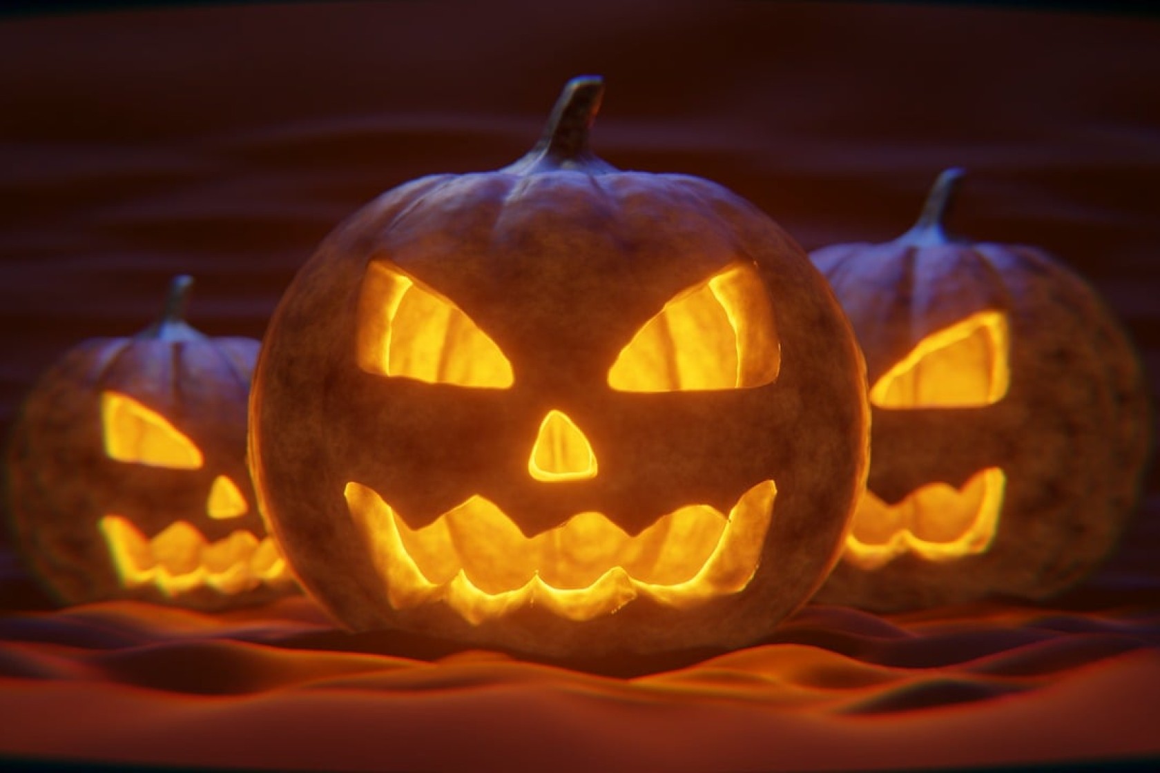 Drie verlichte pompoenen halloweenversiering.